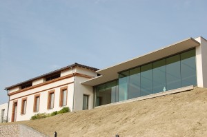 Bâtiment d'origine façade enduite avec tour des fenêtres en briques. L'extension d'architecture moderne à toi terrasse et verrière